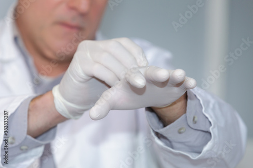 medical staff putting disposable gloves on