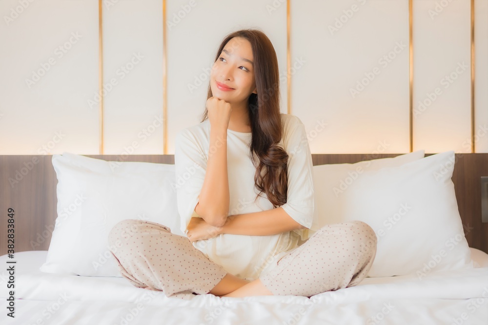 Portrait beautiful young asian woman smile relax on bed in bedroom interior Portrait beautiful young asian woman smile relax on bed in bedroom interior