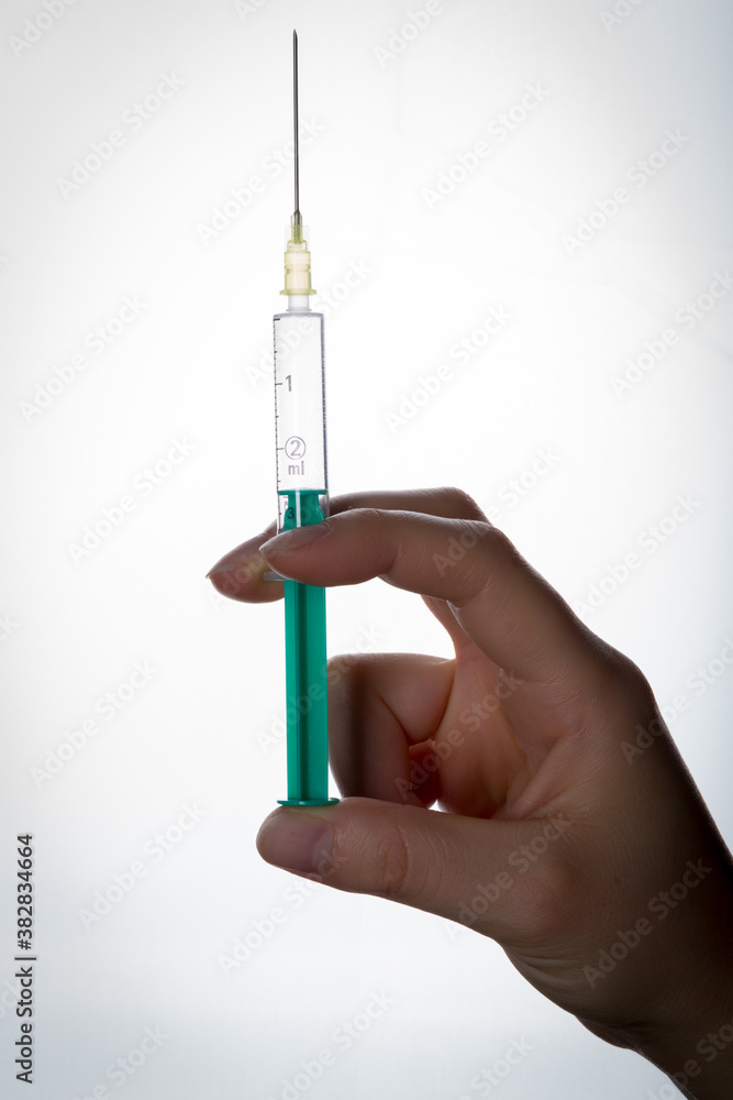bare hand holding a syringe bare hand holding a syringe