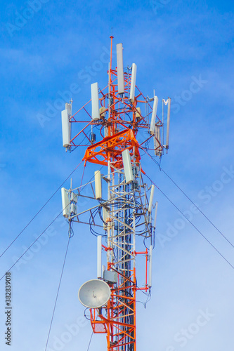 Telecommunication tower with antennas and the blue sky.