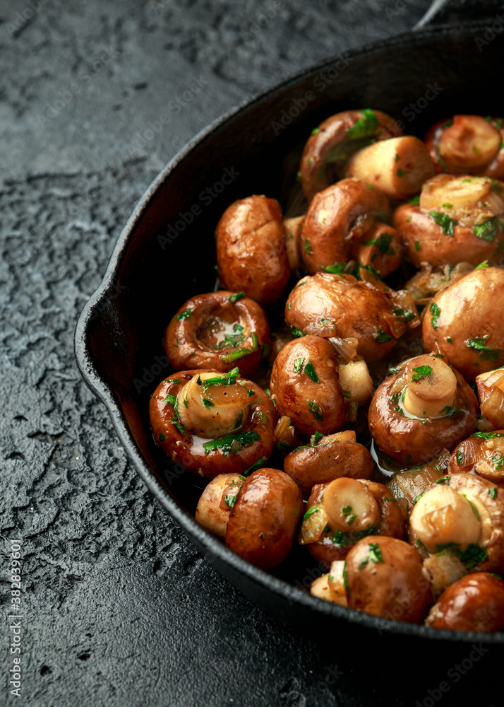 Fried mushrooms with onion and garlic in iron cast pan Fried mushrooms with onion and garlic in iron cast pan