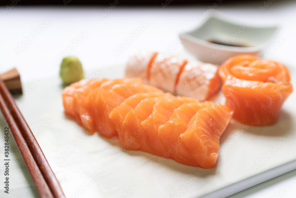 Fresh salmon and toro sashimi with shoyu and wasabi with chopsticks on mable plate. Fresh salmon and toro sashimi with shoyu and wasabi with chopsticks on mable plate.
