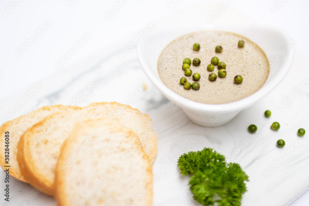 Chicken liver pate with fresh baguette on white mable plate. Chicken liver pate with fresh baguette on white mable plate.