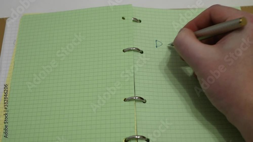 Close up. The hand writes in the diary with a fountain pen, a plan for the day, green paper