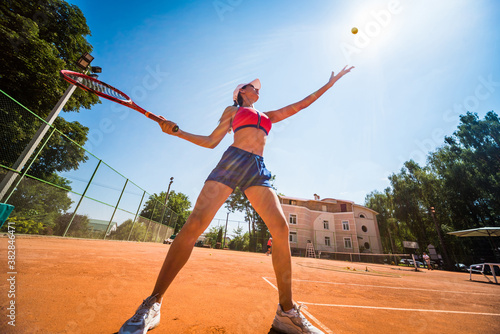 Young athletic woman playing tennis on the court. © romaset