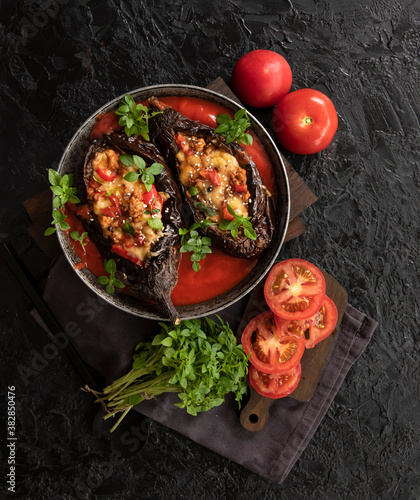 Karniyarik. Stuffed eggplant, eggplant with meat and vegetables, baked with tomato sauce, Turkish cuisine. Top view, close-up.