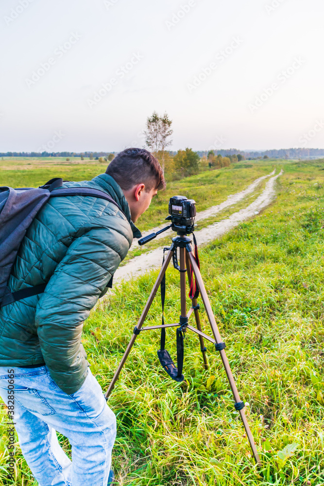 Photographer traveler adjusts the camera   lifestyle professional activity hiker landscape