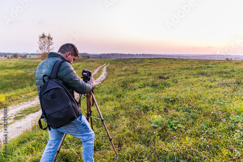 Photographer traveler adjusts the camera lifestyle professional activity hiker landscape