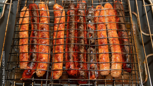 Cooking sausage and merguez on a barbecue, close-up