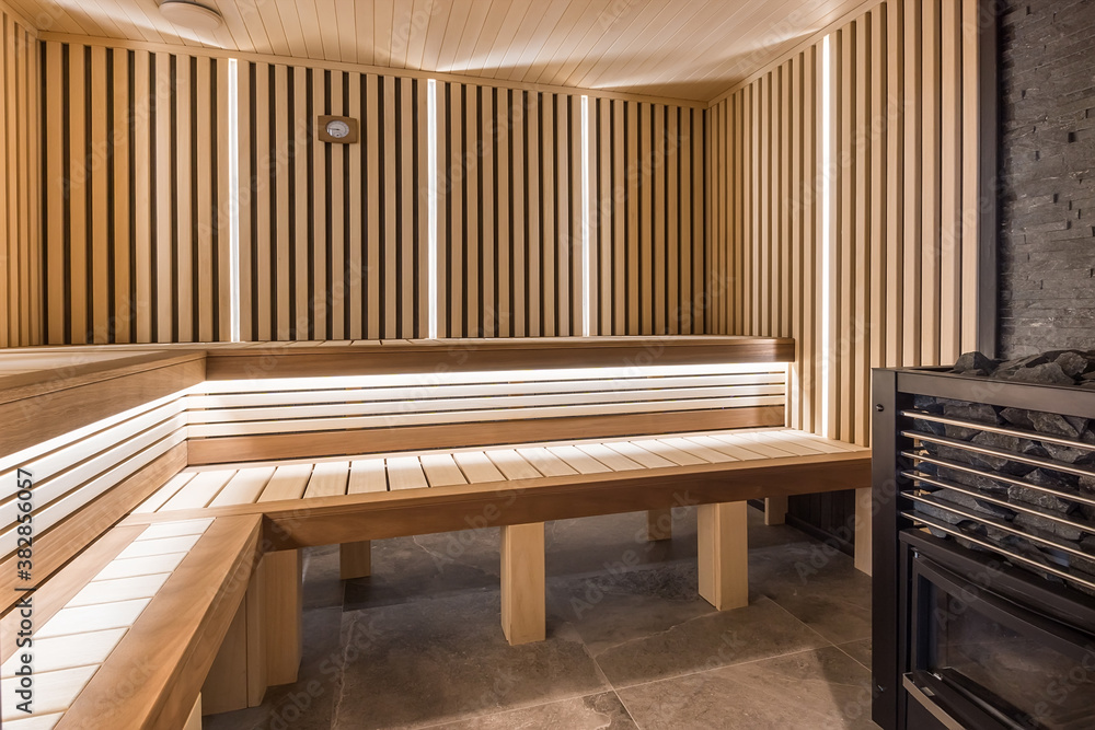Modern wooden sauna interior with elegant lighting and electric heater Modern wooden sauna interior with elegant lighting and electric heater