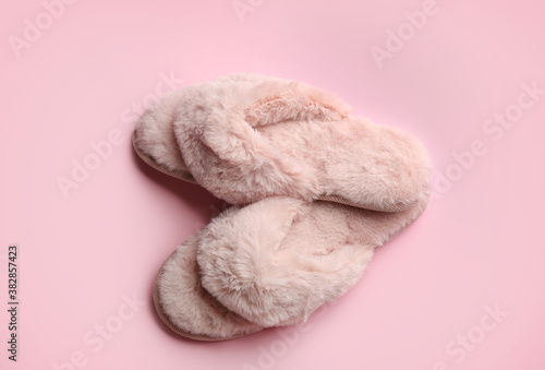 Pair of stylish soft slippers on pink background, flat lay