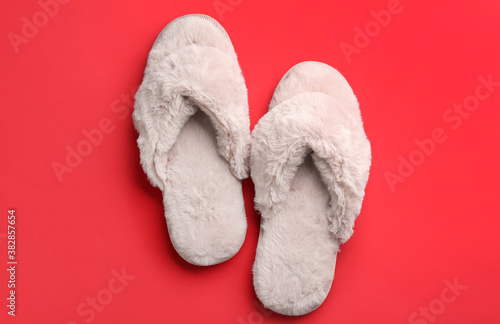 Pair of stylish soft slippers on red background, flat lay