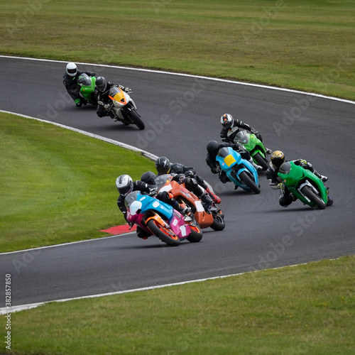 A shot of several racing bikes cornering as they circuit a track.