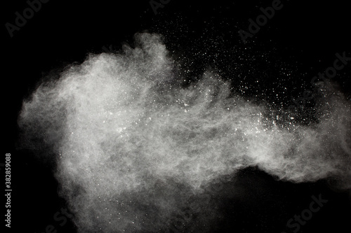 Freeze motion of white dust particles splash on black background.