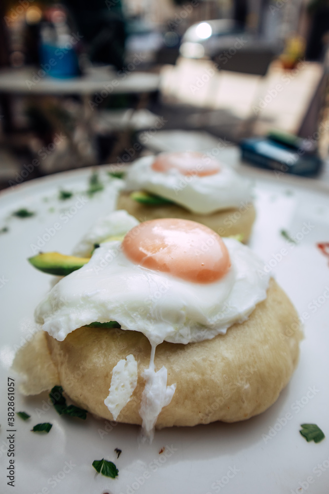 Vegetarian eggs benedict with avocado served on a steamed asian bao bun