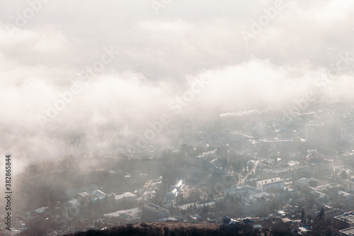 Aerial view of the city through the clouds from the top of the mountain.