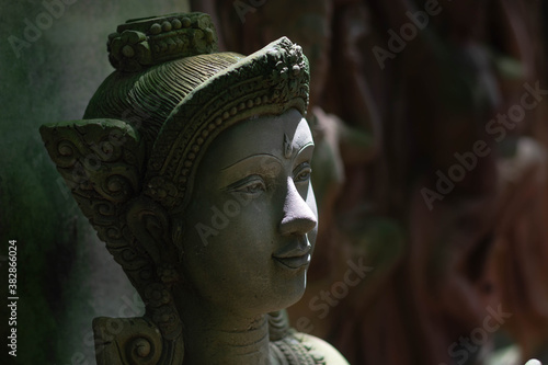 The goddess statue with green moss on the body was placed in a room that was shining. photo