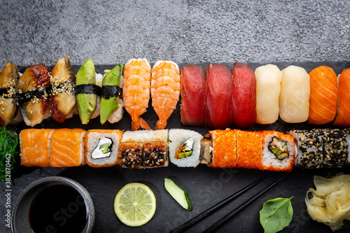 Set of sushi and maki with soy sauce over stone gray background. Top view with copy space