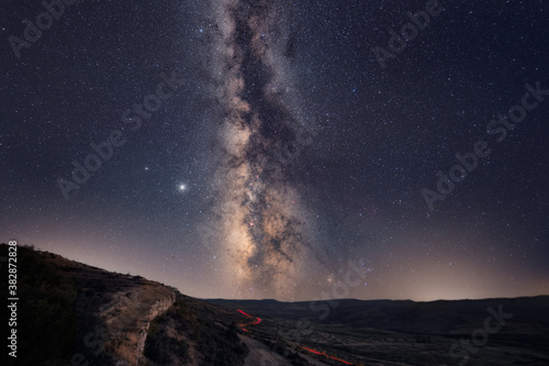 The Milky Way with car light trails on the Foreground Landscape