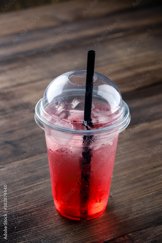 red lemonade with ice in a plastic takeaway glass