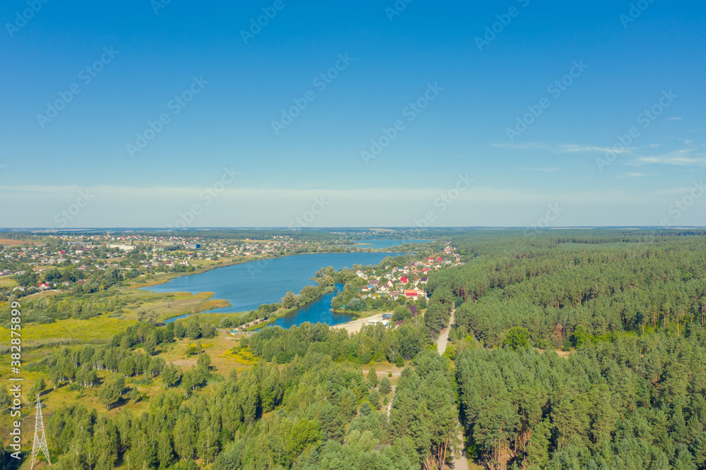 Spring rural landscape in summerю Aerial view. Panoramic view of the village and lake on a sunny day