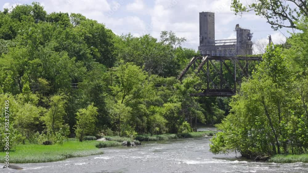 A river with an old abandoned train track draw bridge on it. A river with an old abandoned train track draw bridge on it.