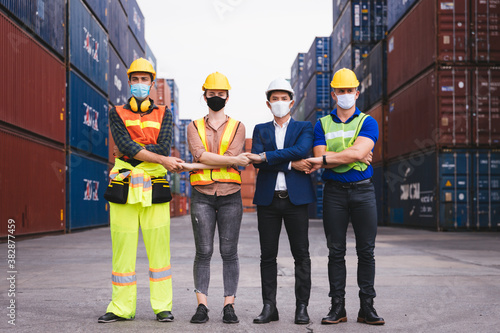 Group of engineer workers wearing mask and safety helmet join hands together of fighting for work. New Normal, Healthcare and Engineering concept.