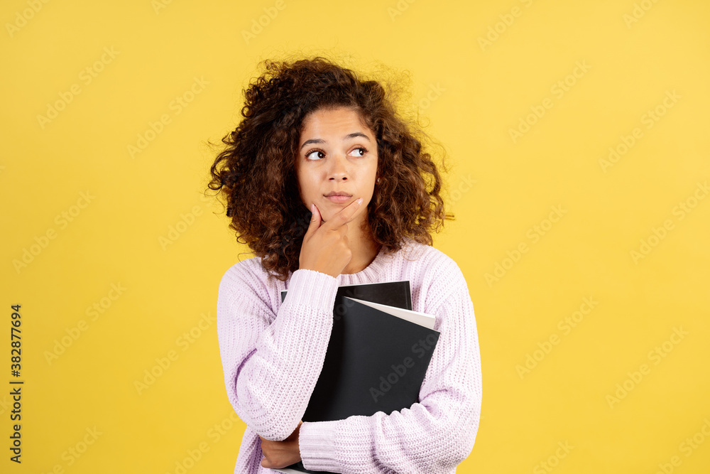 Young afro american woman on yellow copy space background Young afro american woman on yellow copy space background