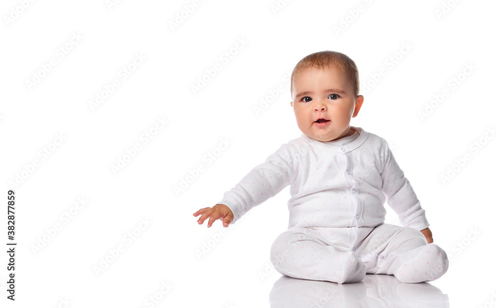 Intrigued baby in a white bodysuit looks to the side on a white background. Intrigued baby in a white bodysuit looks to the side on a white background.