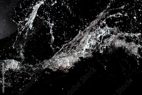 Splash of clear water on black isolated background.