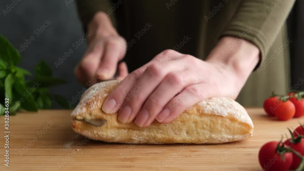 Cutting ciabatta bread. Female chef cut white italian bread in halves