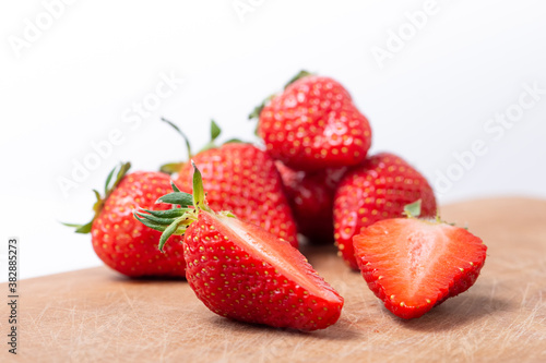 Fresh strawberry in ceramic jar on white