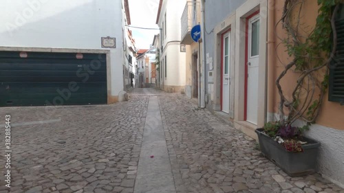 POV cycling down narrow historic alleyway in Cascais, Portugal