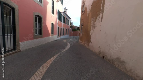 POV cycling down narrow historic alleyway in Cascais, Portugal
