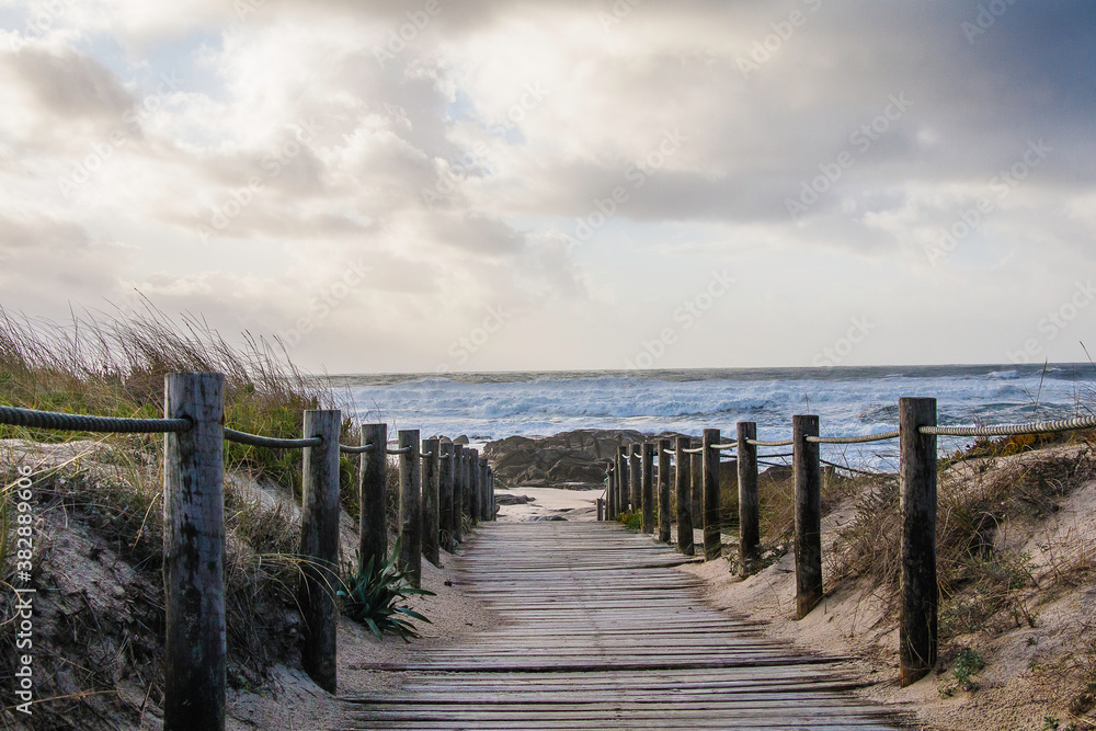 Fototapeta premium Beach wooden fence and corridor on a stormy day
