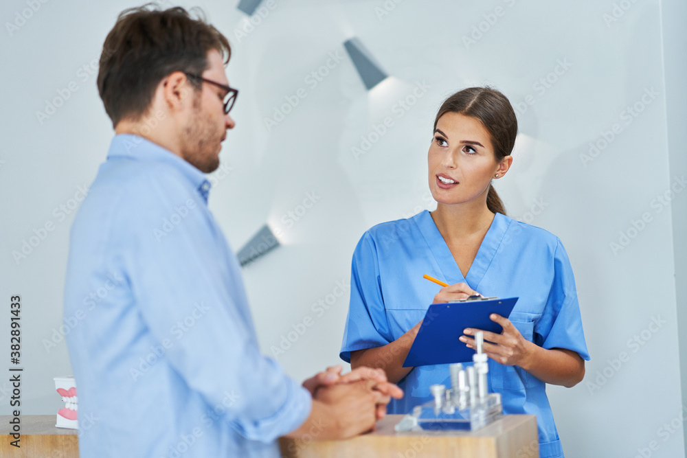 Obraz premium Patient signing documents in dental clinic