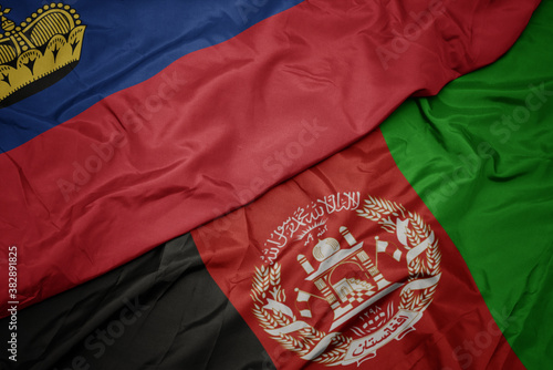 waving colorful flag of afghanistan and national flag of liechtenstein. macro