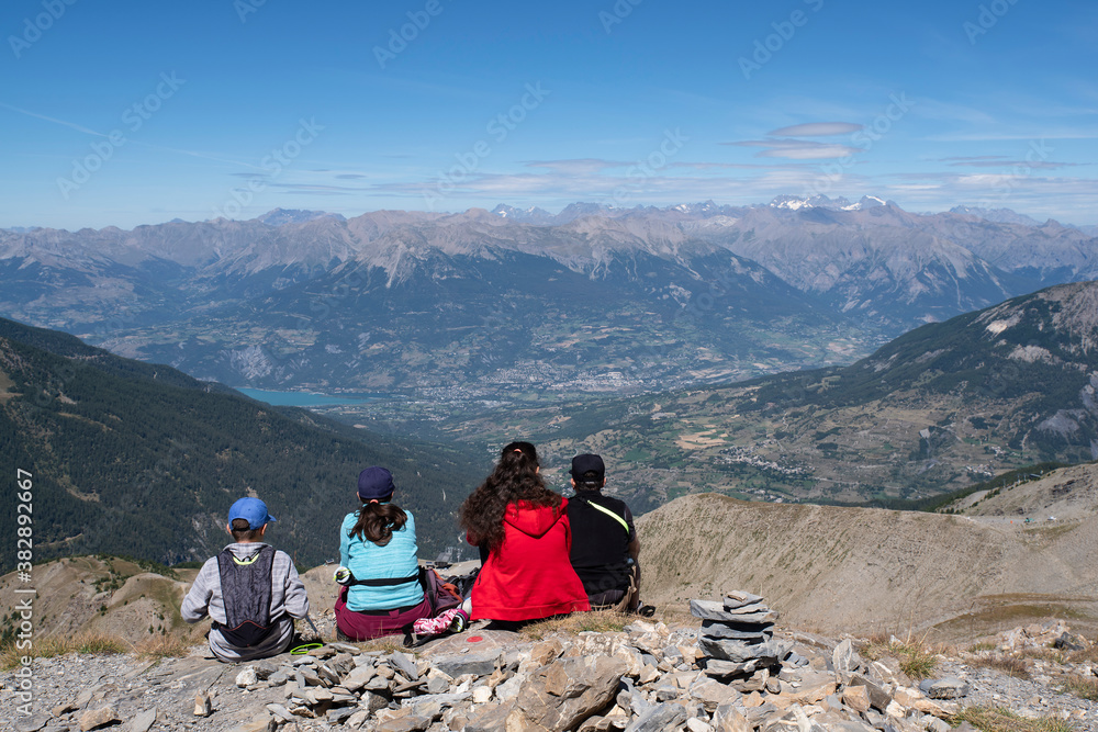 Fototapeta premium A family admiring a mountain landscape from a summit