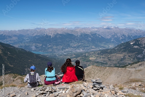 A family admiring a mountain landscape from a summit