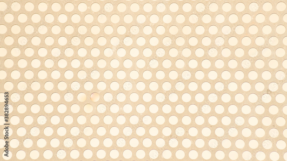 
Beige metal plate perforated with evenly spaced circles