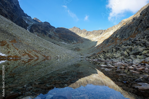 Pond in Valley of Five Spis Lakes surrounded by rocky summits, High Tatra Mountains. Slovakia