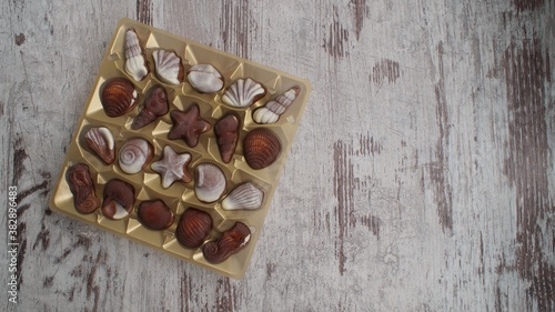 white and brown chocolates in golden pants lying on the counter