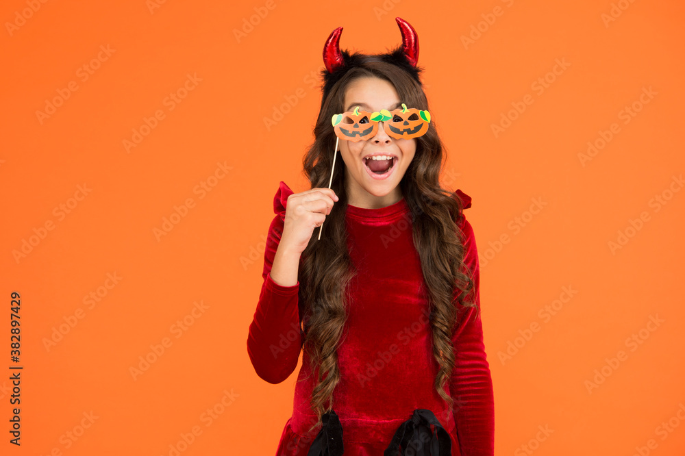 what a surprise. kid wear devil horns. child with funny party attribute. teen girl has curly hair and wear dress for holiday celebration. autumn season holidays. childhood leisure. happy halloween