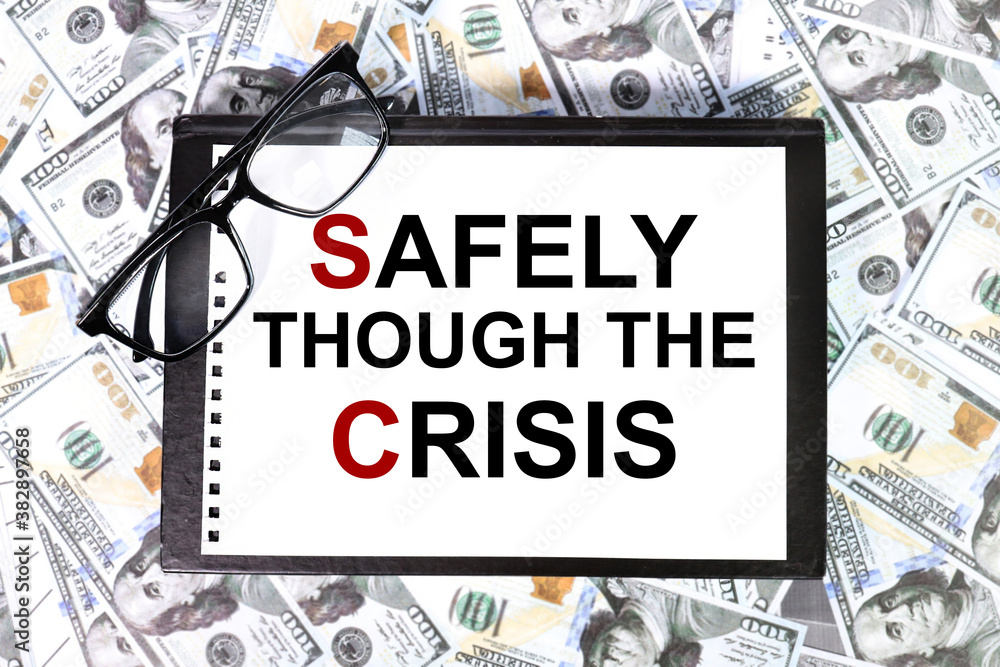 Safely though the crisis, text on white paper over money background