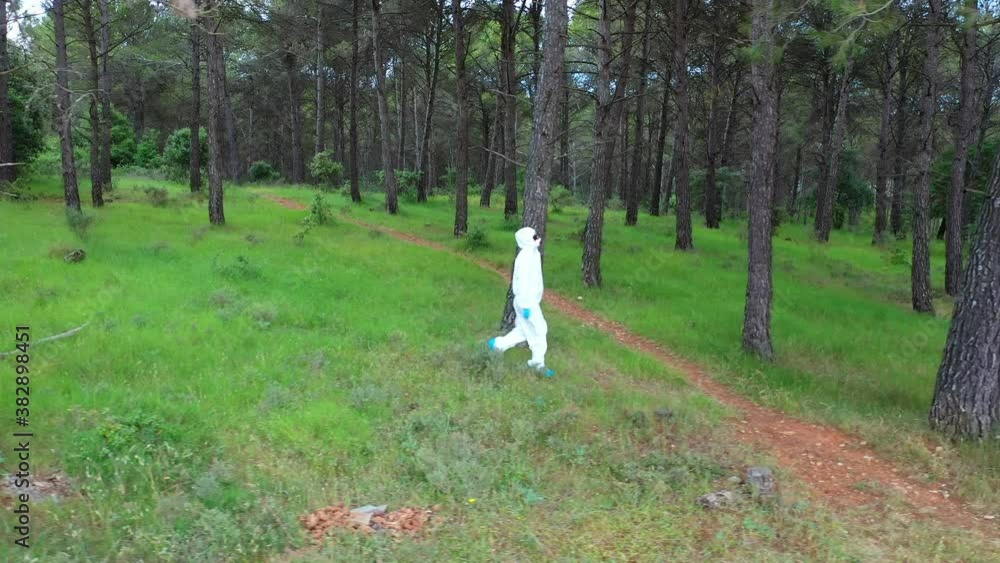 Person with a safety suit walking in a forest area. Ayegui, Navarre, Spain, Europe. Person with a safety suit walking in a forest area. Ayegui, Navarre, Spain, Europe.