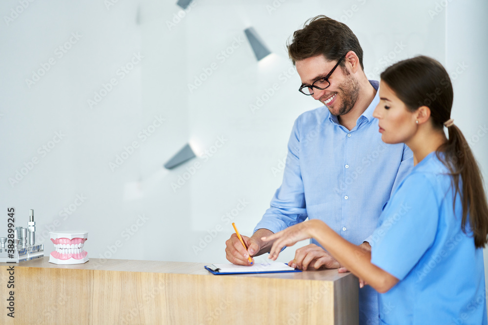 Obraz premium Patient signing documents in dental clinic