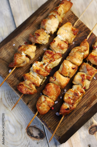 Chicken skewers on wooden sticks. Appetizing homemade mini barbecue. Selective focus. Macro.
