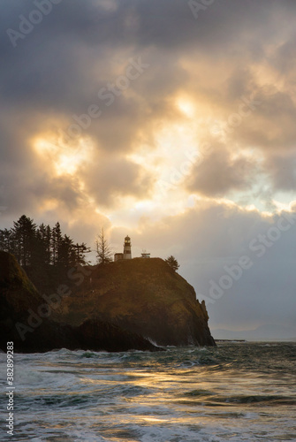 Ocean and sea waves crash against the rocky shoreline during a stormy sunset along the coast of Washington State