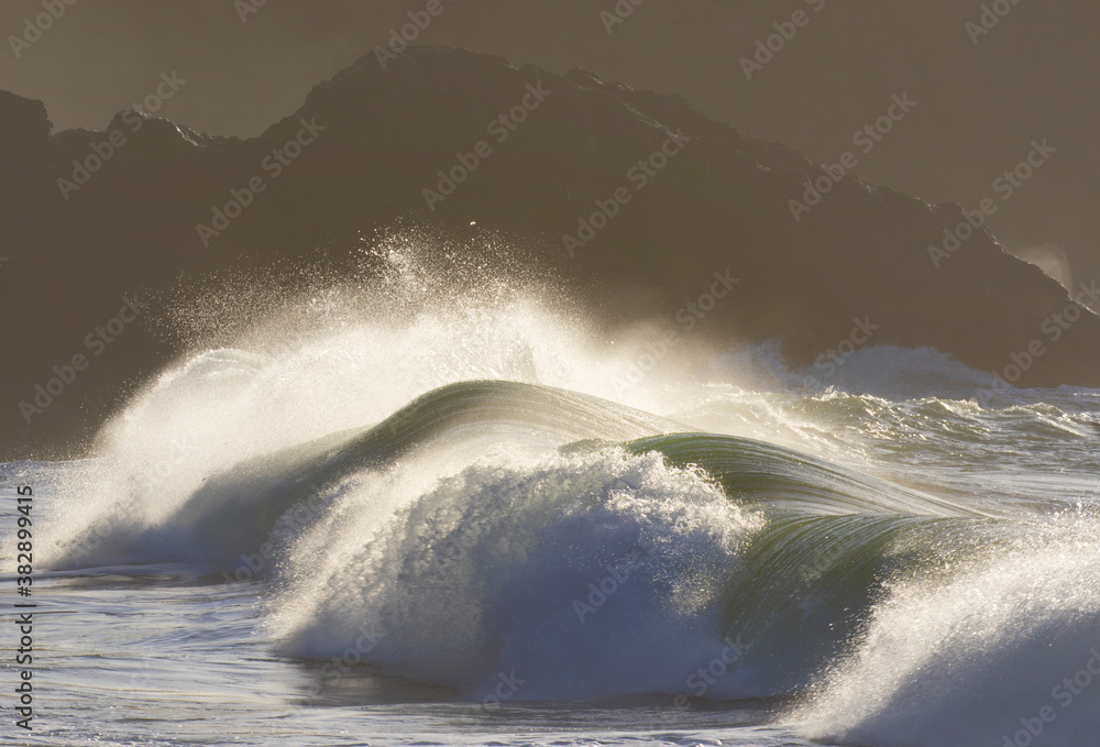 stormy sea and ocean waves crash against the rocky shoreline