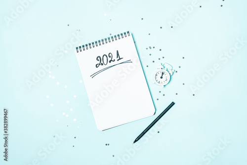 Obraz na płótnie Top view of white vintage alarm clock and empty notebook ready for New 2021 Year planning or wish list'. Copy space. w salonie